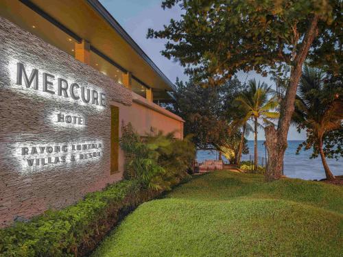 a sign for the meritage hotel with a view of the water at Mercure Rayong Lomtalay Villas & Resort in Mae Pim