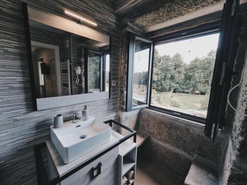 ein Badezimmer mit einem Waschbecken und einem großen Fenster in der Unterkunft Quinta da Abadia in Mangualde