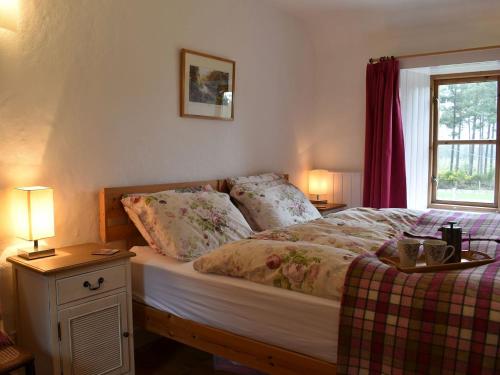 a bedroom with a bed and two lamps and a window at St Orans in Rafford