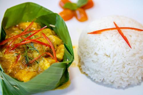 a plate of food with rice and a meal at Bliss & Beats Hostel in Phnom Penh