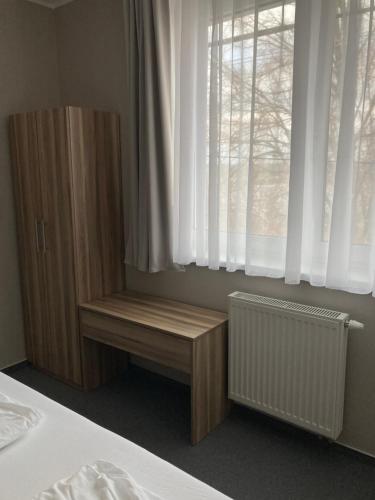 a bedroom with a wooden bench next to a window at Penzión Fonte in Radava