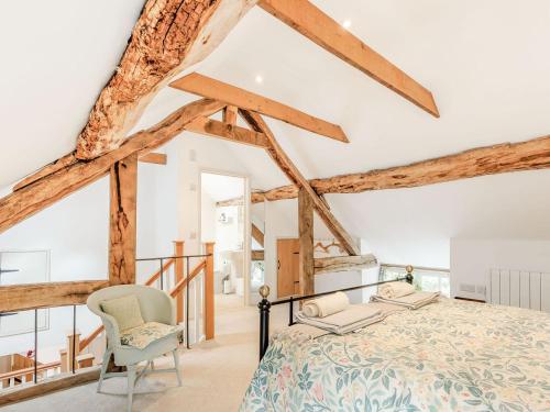 a bedroom with a large bed and a chair at The Old Milking Parlour in Wentnor