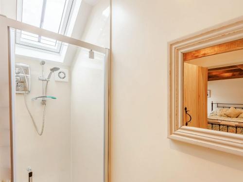 een badkamer met een douche en een spiegel bij The Old Milking Parlour in Wentnor