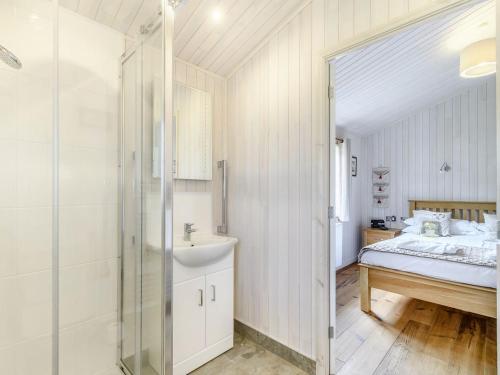 uma casa de banho com uma cama, um lavatório e um chuveiro em Acacia Lodge em Willington