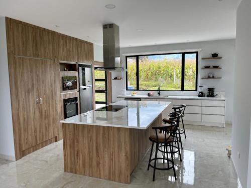 a kitchen with wooden cabinets and a counter with bar stools at Altos de Tababela in Tababela