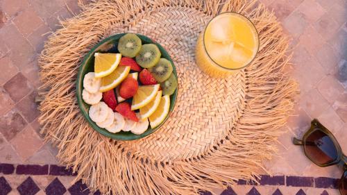 een fruitschaal op een tafel met een glas sap bij Riad Dar Elma And Spa in Marrakesh
