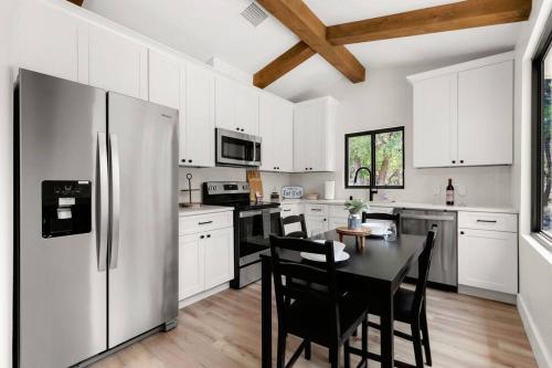 a kitchen with a refrigerator and a table with chairs at Casita 5 minutes from Gruene Hall and King Bed! in New Braunfels
