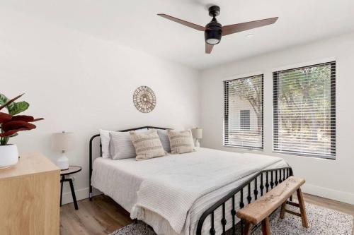 a white bedroom with a bed and a ceiling fan at Casita 5 minutes from Gruene Hall and King Bed! in New Braunfels