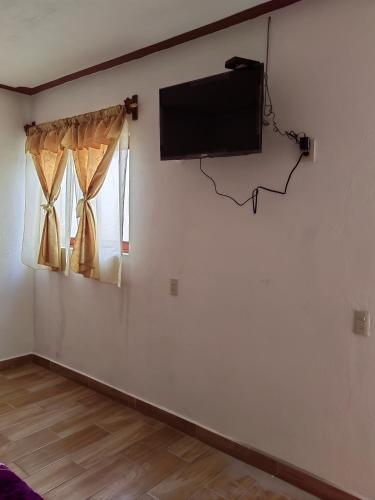 a room with a flat screen tv on a wall at Posada villa aurora in Bernal