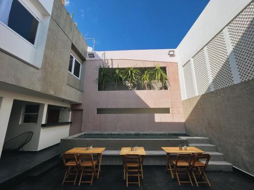 a patio with tables and chairs in a building at Casa Oxa Hotel in Querétaro