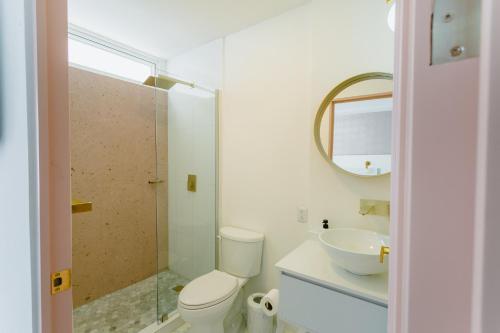 uma casa de banho com um WC, um lavatório e um espelho. em Casa Oxa Hotel em Querétaro