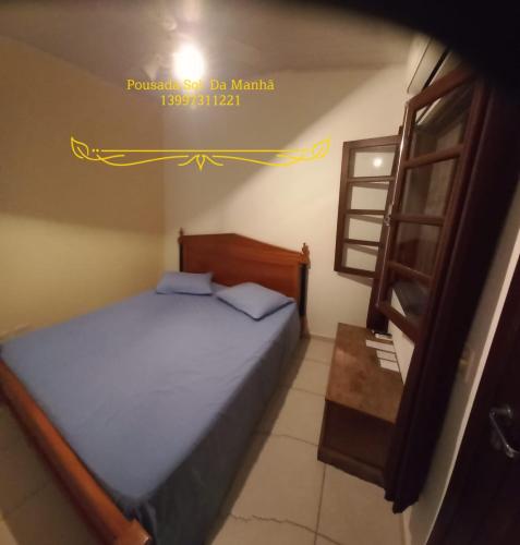 a small bedroom with a bed and a window at Pousada Sol da Manhã in Guarujá
