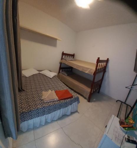a small room with two beds and a bunk bed at Pousada Sol da Manhã in Guarujá