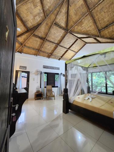 Jungle Inn Bukit lawang في بوكيت لاوانج: غرفة نوم بسرير كبير في غرفة