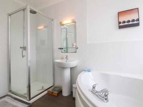 a bathroom with a tub and a sink and a shower at Hele Beach in Ilfracombe
