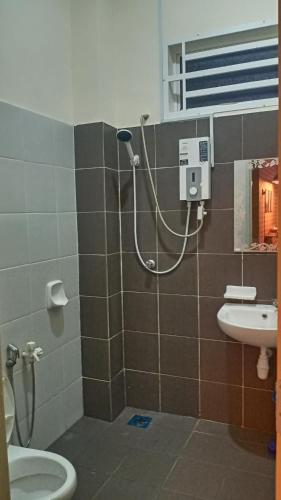 a bathroom with a shower with a toilet and a sink at illa Bella Homestay Jasin in Jasin