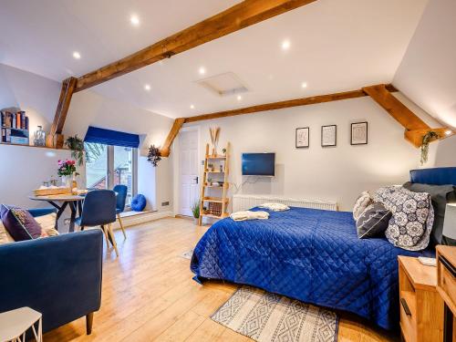 a bedroom with a blue bed and a desk at Dassett View in Fenny Compton