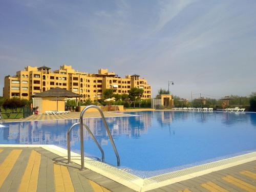 a large swimming pool with buildings in the background at Apartment on The Beach Front with Free Fibre Internet and Air Conditioning in Isla Canela