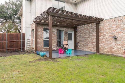uma pérgola com uma mesa e cadeiras num quintal em Grand Gem for Families - Games, Office, Backyard em Carrollton
