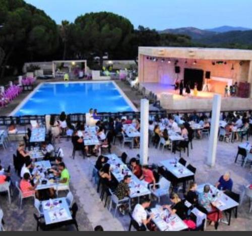 a group of people sitting at tables in front of a pool at Camping les Cigales - Mobil-home 4/6 personnes in Le Muy