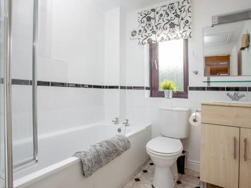 a bathroom with a tub and a toilet and a sink at Ted n Bettys in Buckfastleigh