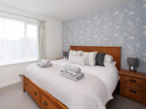 1 dormitorio con 1 cama con toallas en Barn Owl Cottage, en Inver