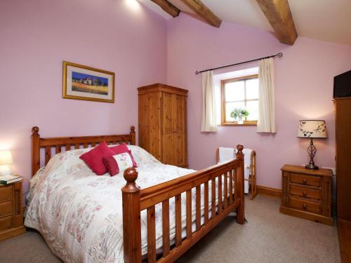 a bedroom with a wooden bed and a window at Bramble Cottage - Uk4186 in Hazlehead Bridge