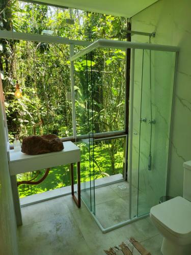 bagno con doccia in vetro e servizi igienici di Maresias Beach Housing - Mata Azul a São Sebastião