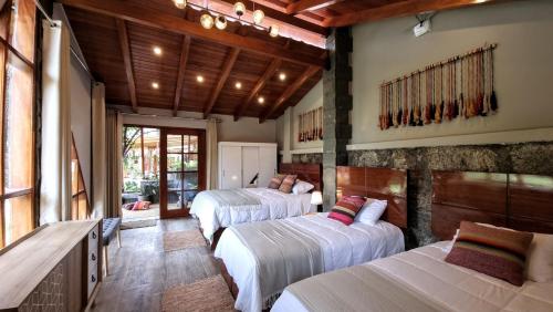 a bedroom with three beds in a room at Huandoy Lodge - Huaraz in Yungay