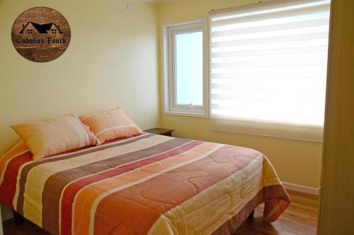 1 dormitorio con 1 cama grande y ventana en Cabañas Fonck II, en Puerto Montt