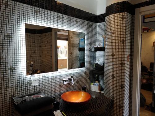 a bathroom with a wooden sink and a mirror at Andy's cozy little place in Baggio