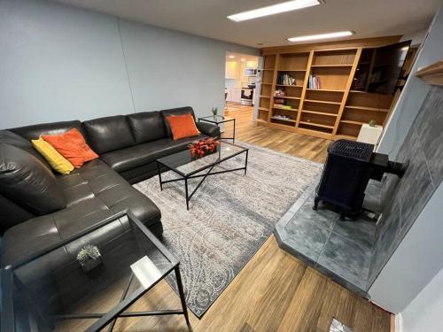 a living room with a leather couch and a fireplace at Cozy Home for Family & Friends Gathering in Beaverton