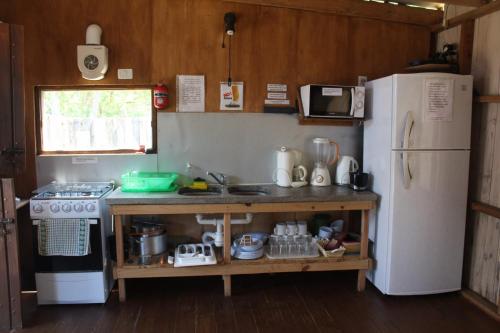 y cocina con fogones y nevera. en Rancho Azul, en La Pedrera