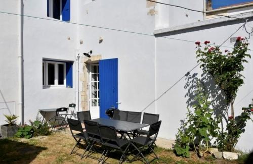 une table et des chaises devant un bâtiment blanc dans l'établissement DOLUS, Maison à 10 min. de la plage!, à Dolus-d'Oléron