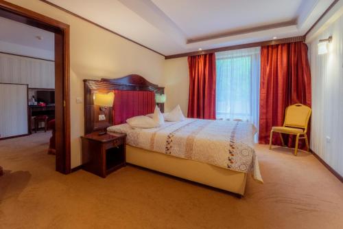 a hotel room with a bed and a window at Hotel Perla in Slănic-Moldova