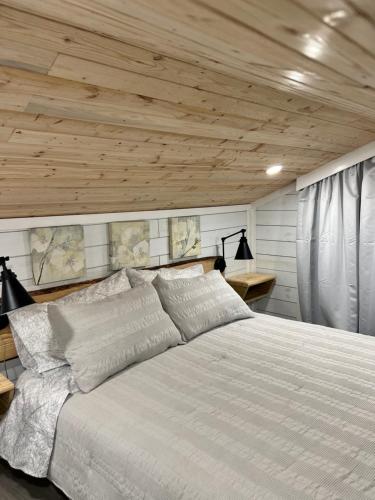 a bedroom with a white bed with a wooden ceiling at Maria's Tiny Barn in Homestead