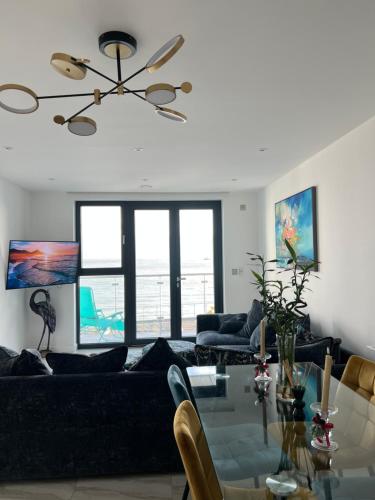 uma sala de estar com um sofá e uma mesa de vidro em Royal View em Ramsgate