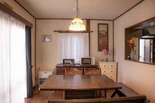 a dining room with a wooden table and a window at 一組貸切宿 岡村 弐番館 limited to 1group per day 一棟まるまる貸切 in Suwa