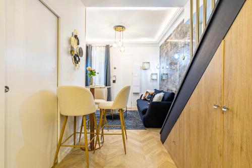 un salon avec une table et des chaises et un escalier dans l'établissement Le studio de l'île, à Paris
