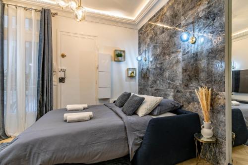 a bedroom with a bed and a large stone wall at Le studio de l'île in Paris