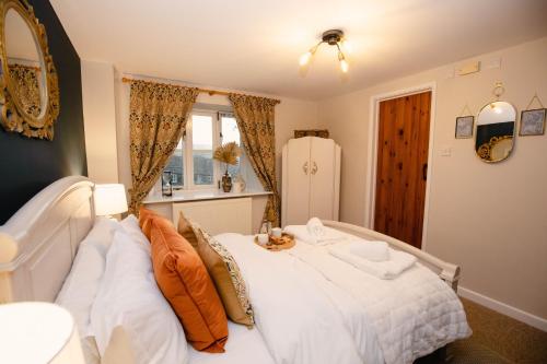 Stable Cottage - Rudge Farm Cottages في بريدبورت: غرفة نوم بسرير ابيض كبير ونافذة