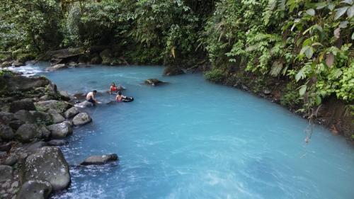 a group of people in a river in the jungle at Río Celeste Nature View in Upala