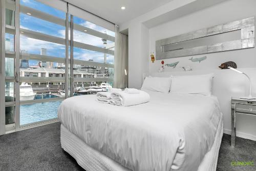 Un dormitorio blanco con una cama grande y una ventana en QV Modern Waterfront 2-bedroom apartment - 079 en Auckland