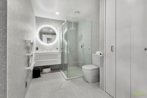 y baño con ducha, aseo y espejo. en QV Modern Waterfront 2-bedroom apartment - 079 en Auckland