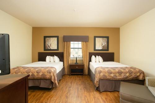 um quarto de hotel com duas camas e uma televisão de ecrã plano em The Lodge At Kenedy em Kenedy