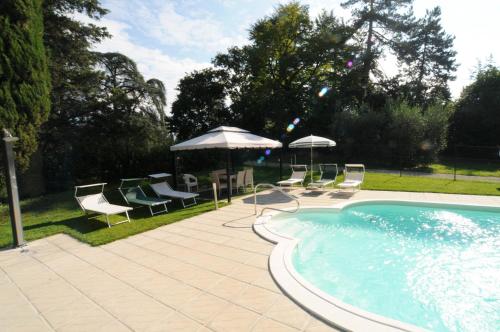 a swimming pool with chairs and umbrellas next to at Villa Torricelli Scarperia - Il Giardinetto Residence in Scarperia