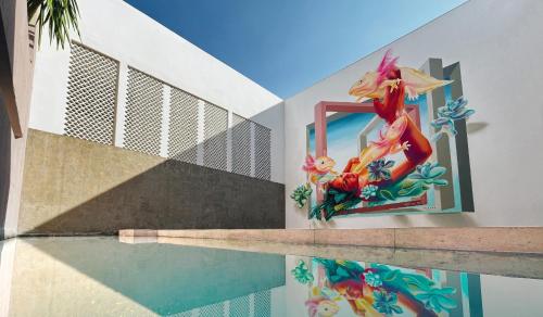 a pool with a mermaid mirror on the side of a building at Casa Oxa Hotel in Querétaro