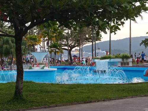 uma fonte num parque com pessoas na água em Ponta da Praia amplo 3dorm 3ban frente ao mar em Santos