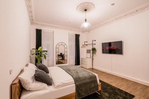 um quarto com uma cama e uma televisão na parede em LivingKreuzberg - Stilvolle Altbauwohnung em Berlim