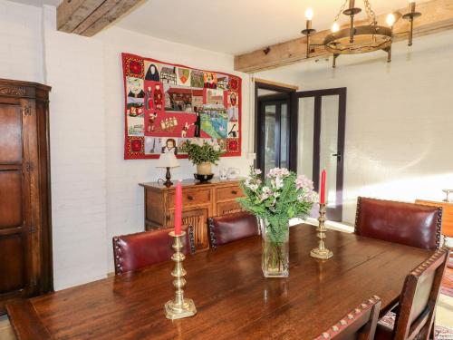 a dining room with a wooden table with two candles at Gatehouse Croft in Newton Regis